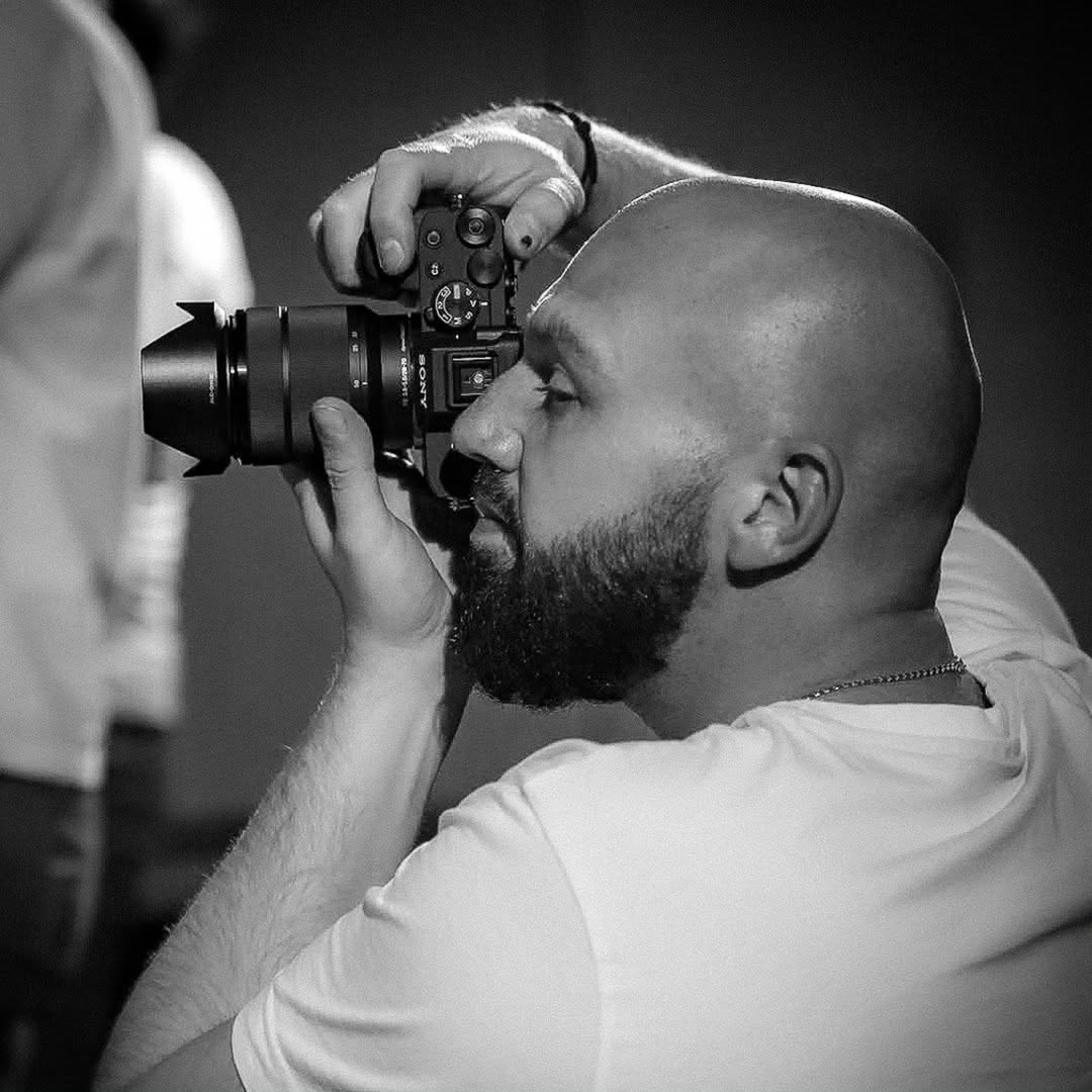 Mateusz Miklaszewski fotografujący aparatem